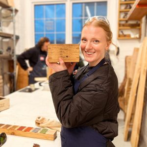 woman holding a trinket box from the rivershop carpentry course london